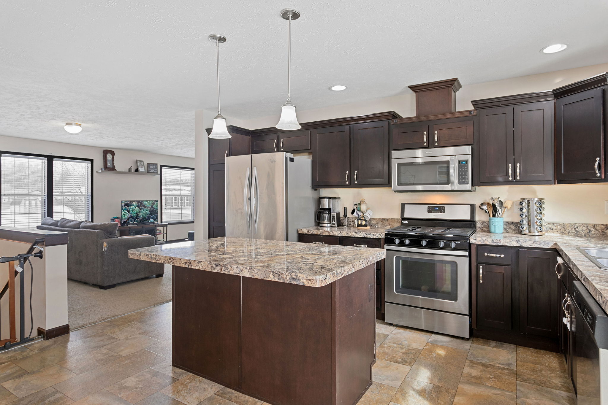 Updated kitchen with stainless steel appliances, dark wood cabinetry, and a center island.