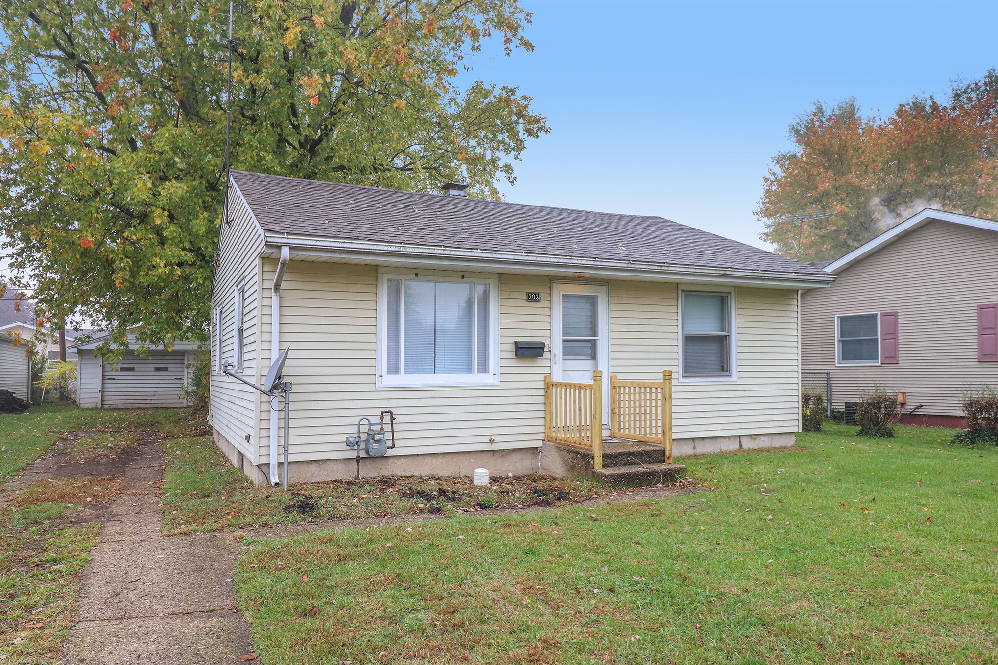 Single-story vinyl-sided home with small porch and detached garage in South Bend, IN.