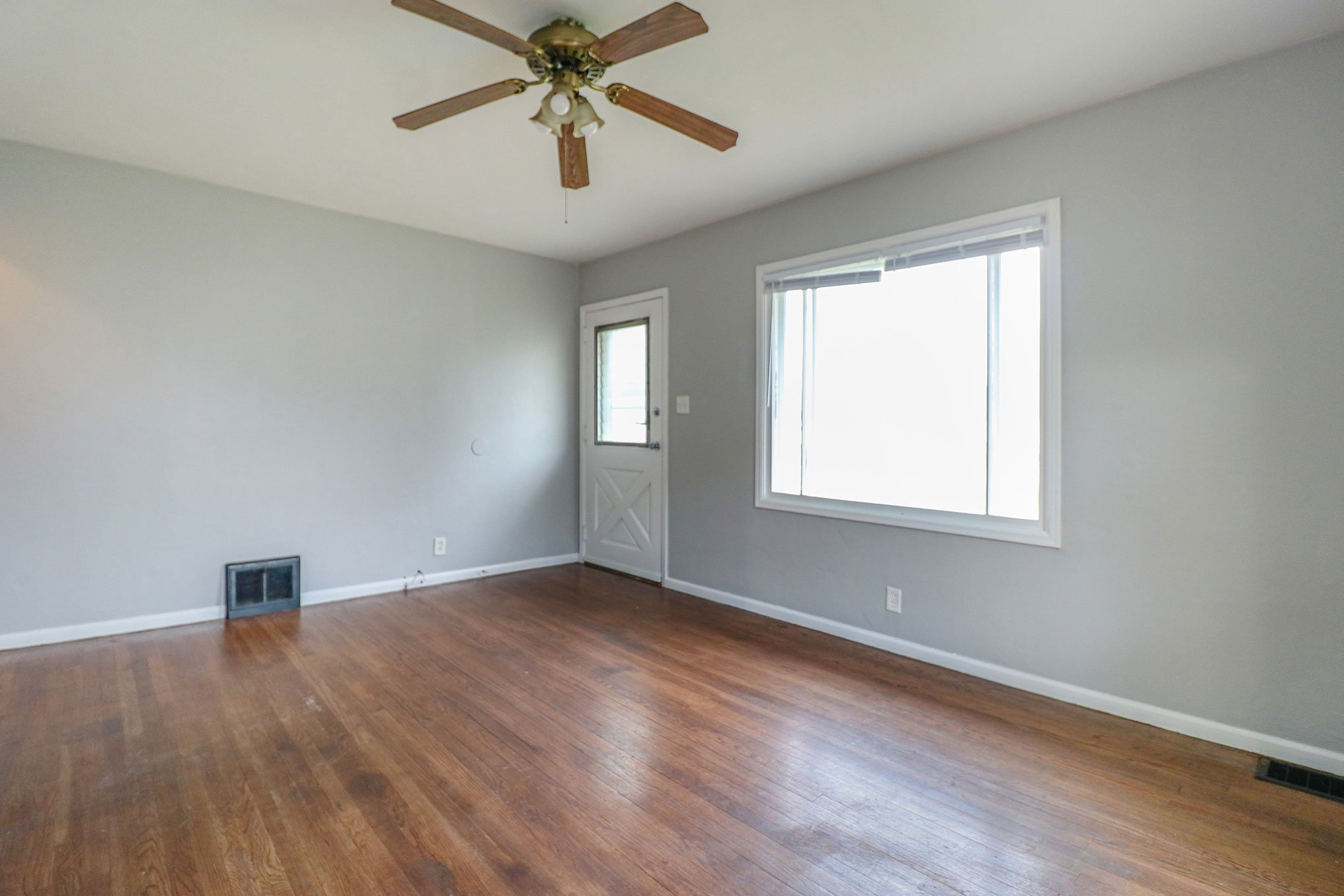 Front entry and large window in living space with hardwood floors in South Bend, IN home.